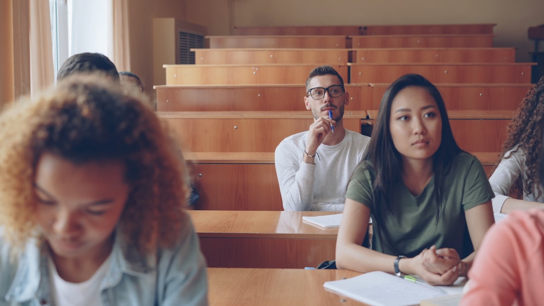 Diverse students listening attentively in a tiered lecture hall