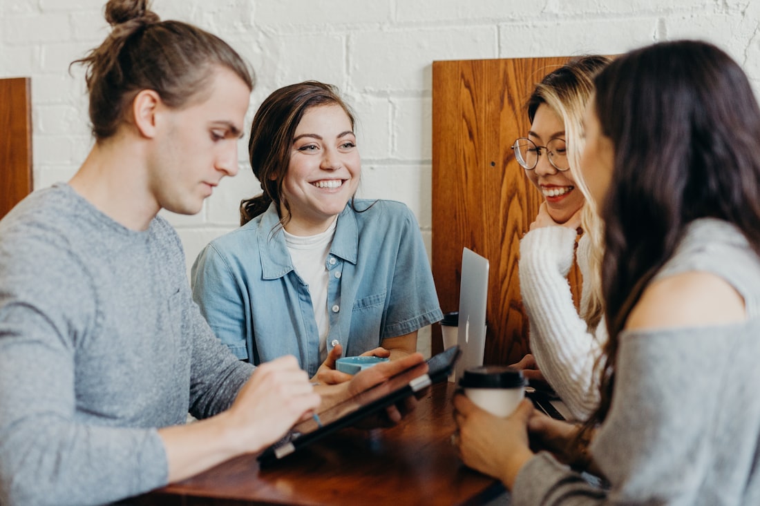 A diverse group of college students talking together around a table